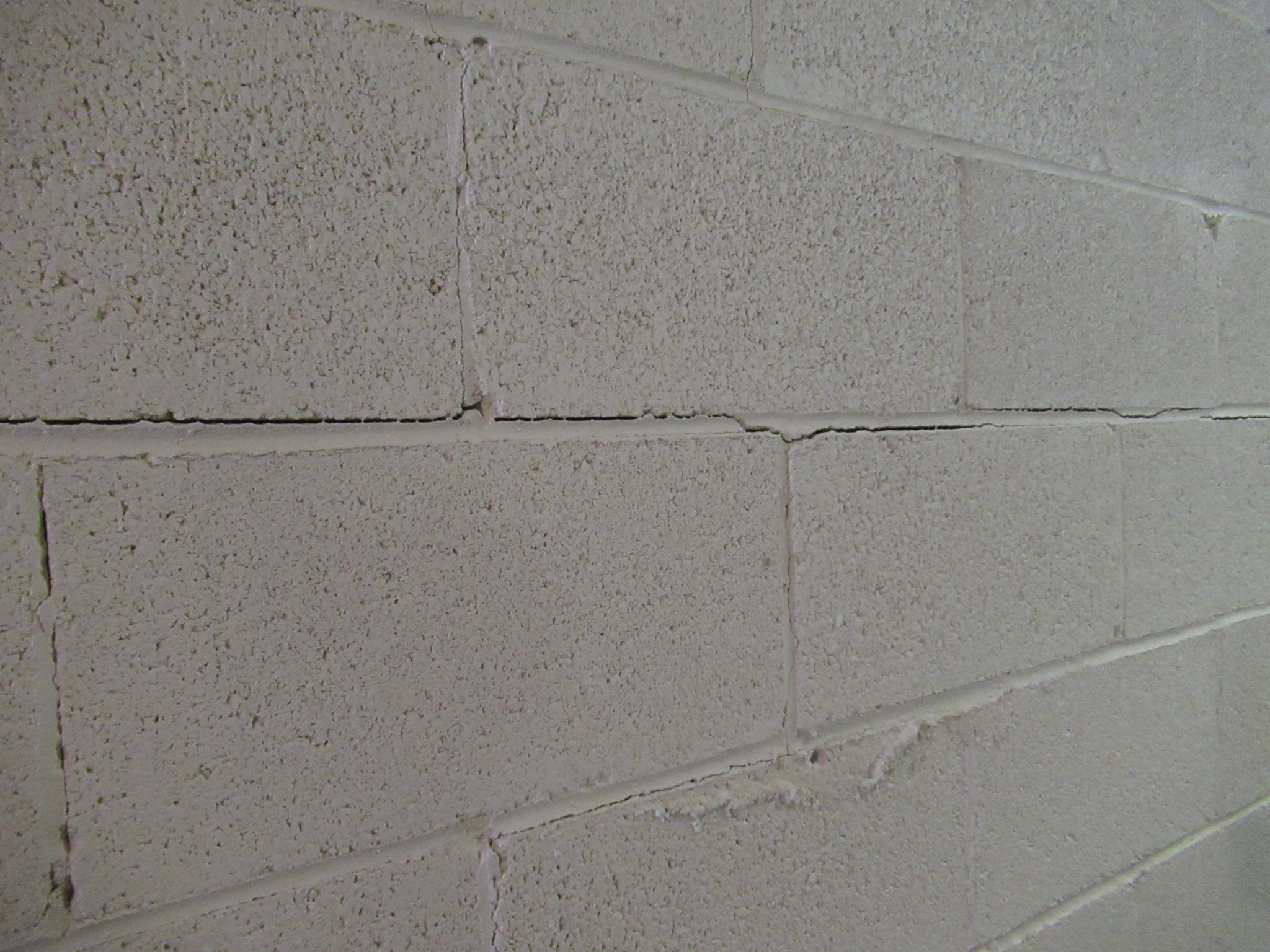 A basement concrete wall with a long horizontal crack running several feet