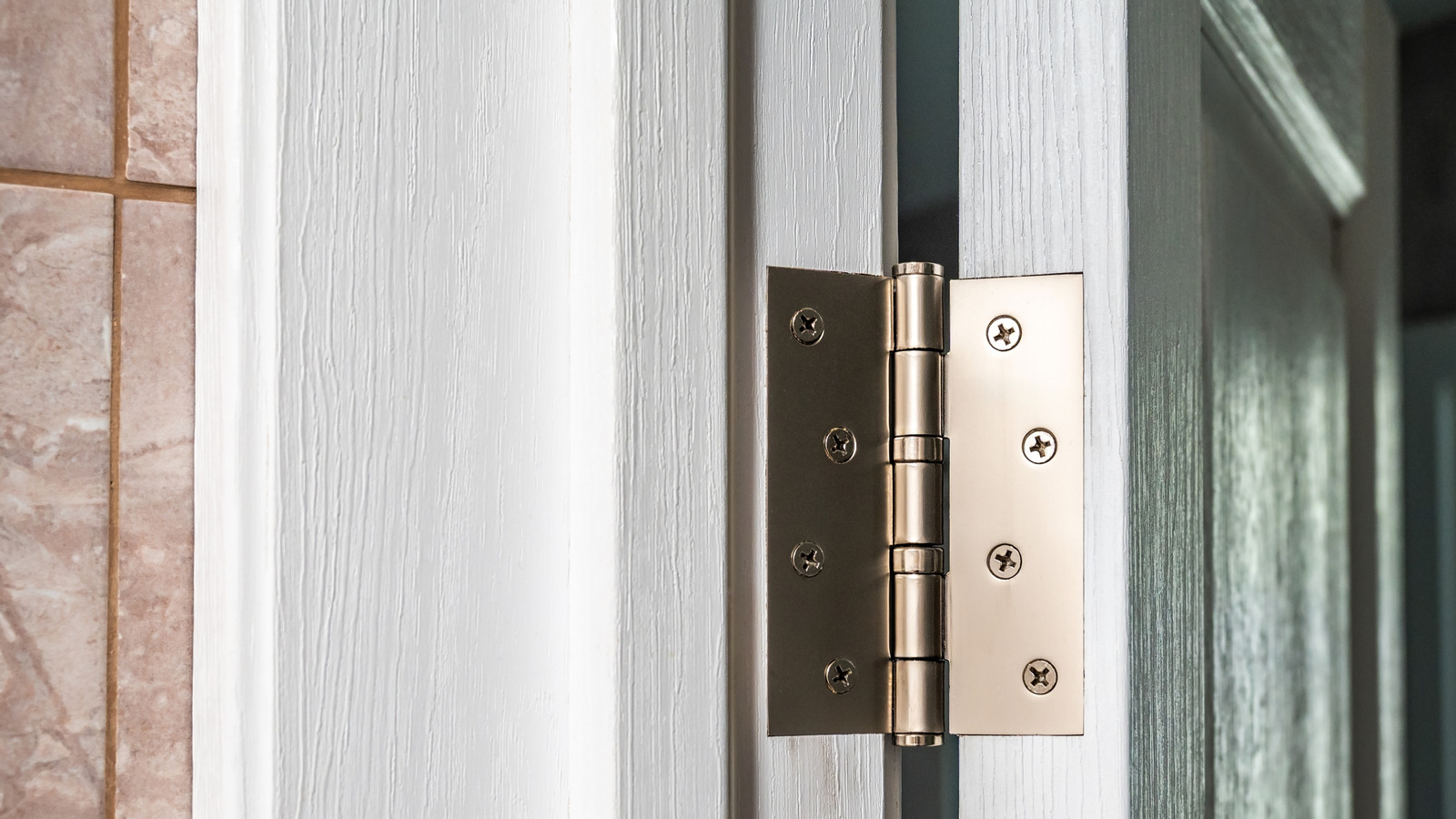 A plain bar of soap being rubbed along the hinge knuckle seam of an interior door hinge
