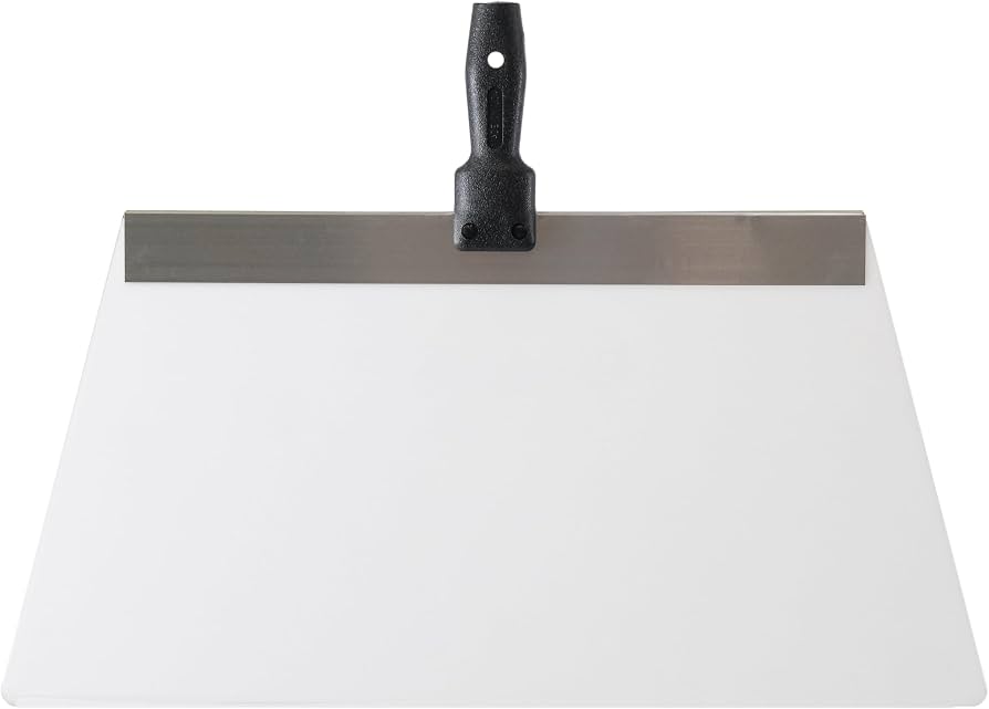 A wide knockdown knife being pulled across freshly sprayed ceiling texture to flatten the peaks