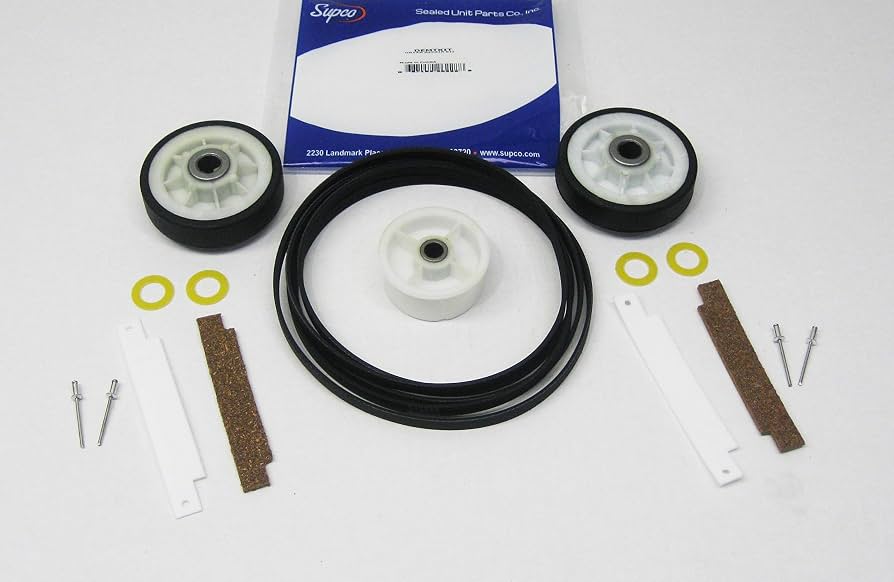 Common dryer wear parts on a workbench, including a drive belt, drum rollers, and an idler pulley assembly