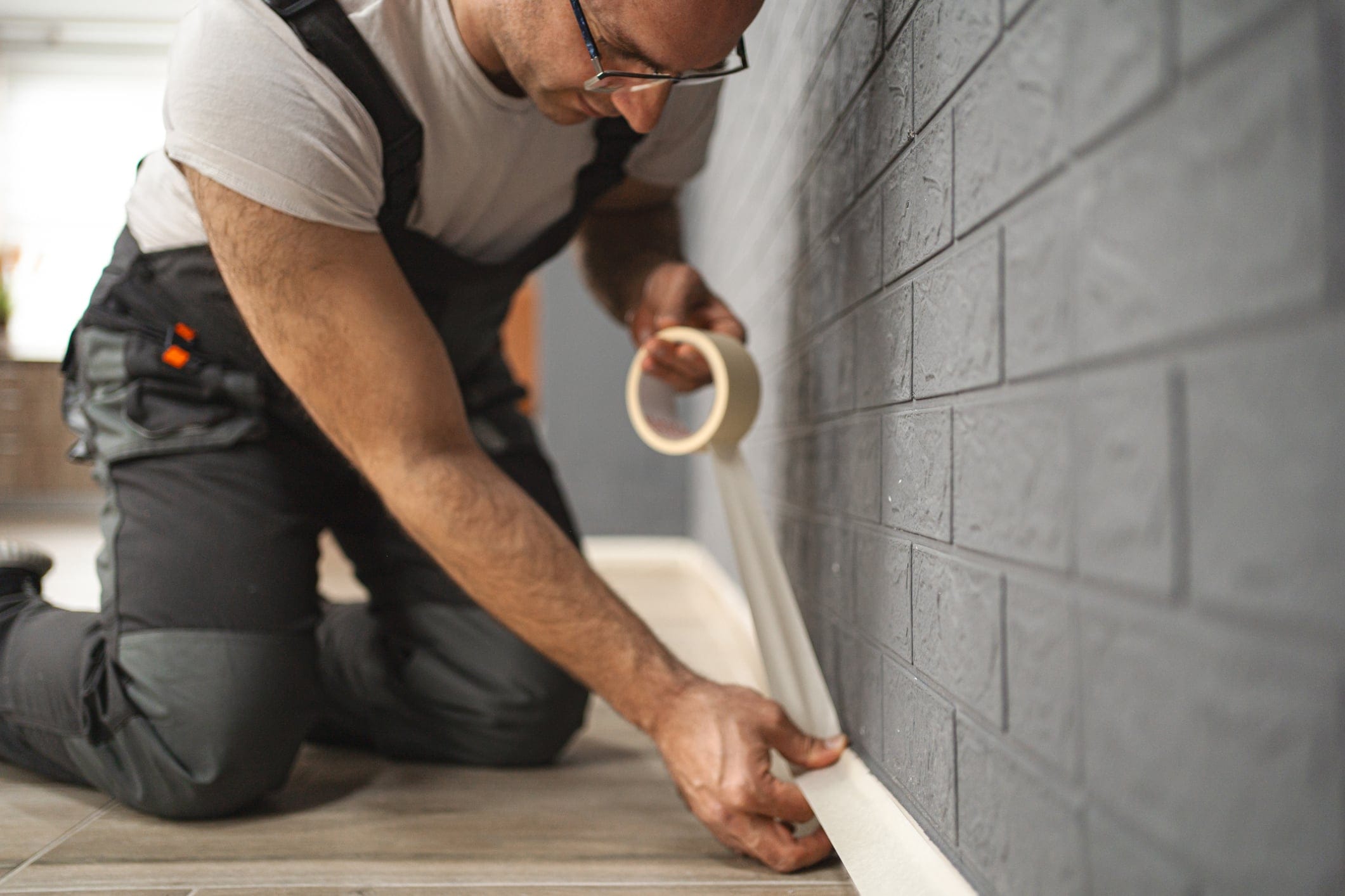Painter’s tape applied around the edges of a tile to protect adjacent tiles during removal
